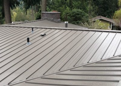 A residential roofing contractor installing a metal roof in a neighborhood.