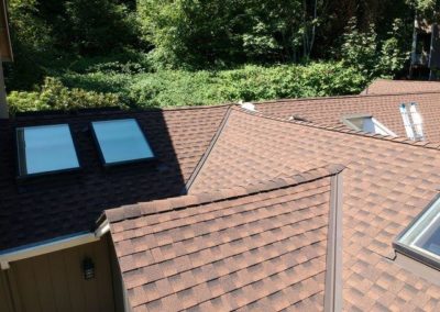 A brown roof with two skylights on it, installed by a residential roofing company.