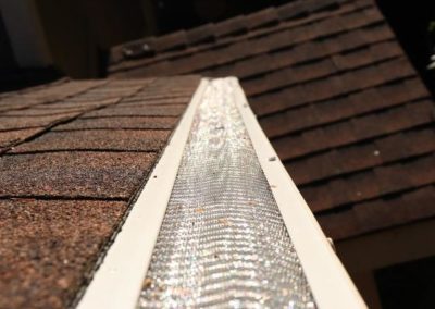 A residential roofing installation featuring a gutter on top.