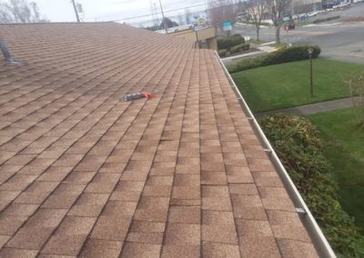 A brown shingled roof with roofing shingles on it.