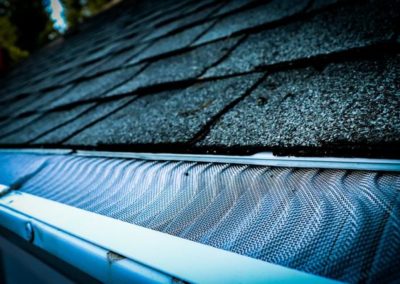 A close up of a metal gutter on a roof, showcasing excellent residential roofing.