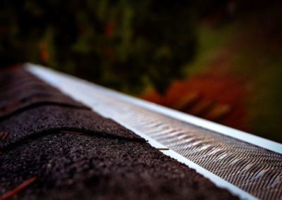 A close up of a residential roof with gutters.