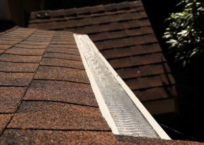 A roofing company specializing in roof replacement, with a shingled roof featuring a gutter.