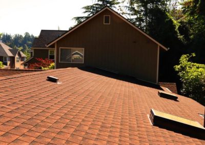 A roof with a red shingled roof installed by a residential roofing contractor.