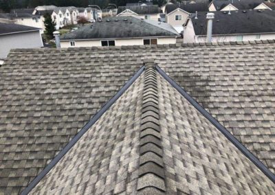 The roofing contractor completed a roof replacement on a house with shingles.