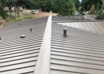 A metal roof installation in a residential neighborhood by a roofing contractor.