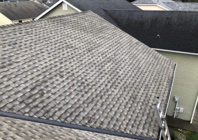 The house roof with shingles, installed by a roofing company.